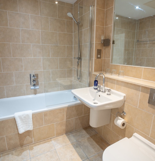 Bathroom with shower over tub in Feature Family Room