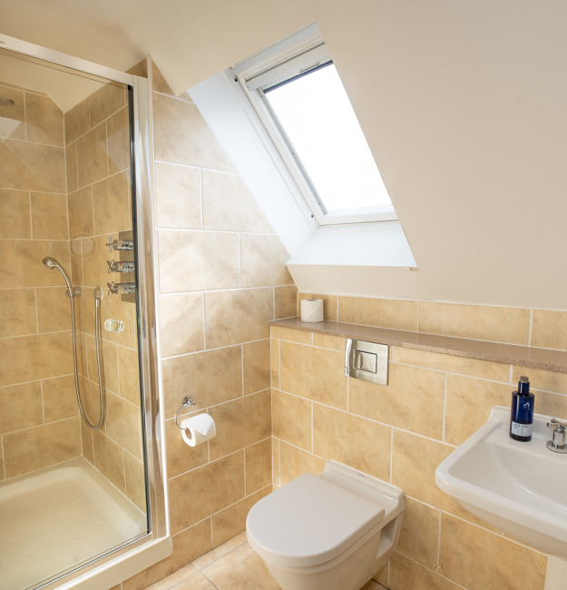Bathroom with shower, toilet, and sink.