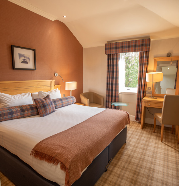 Studio apartment living area with corner sofa, coffee table, kitchen unit with microwave and sink.