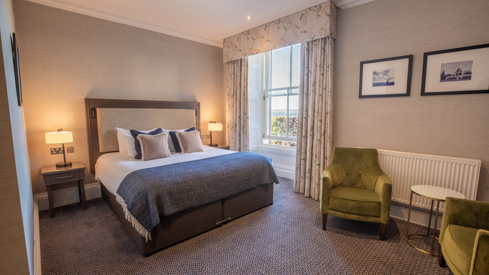 King-sized bed, bedside table, two chairs and a window