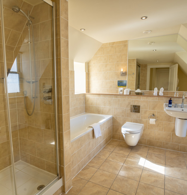 Bathroom with separate shower and bath, toilet, sink and mirror.